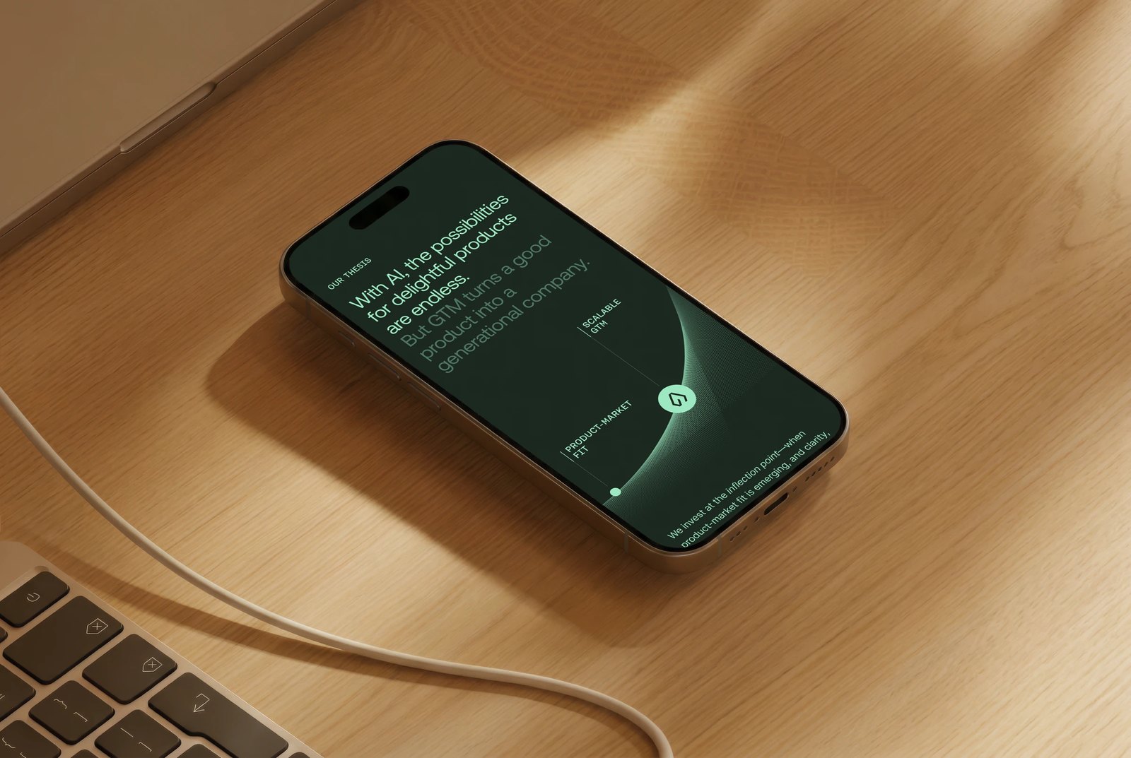 Smartphone held in hand on a desk showing the Tenacity Capital website